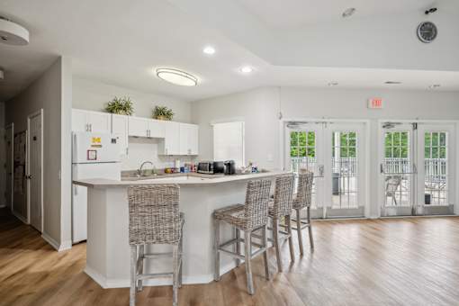 A kitchen with a table and chairs in front of a window.