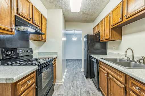 A kitchen with black appliances and wooden cabinets.