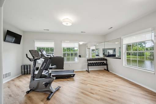 A spacious room with a treadmill and a television.