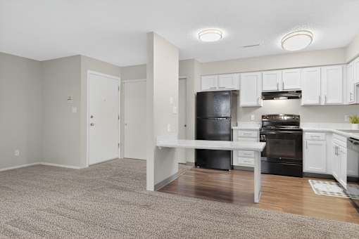 A kitchen with black appliances and white cabinets.