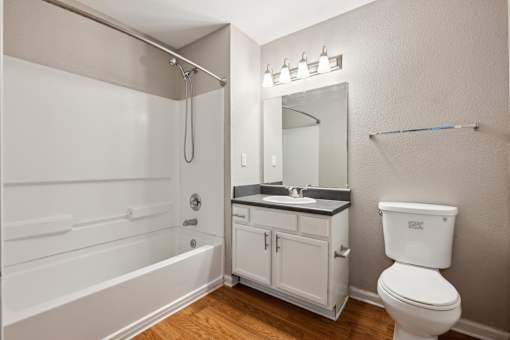 A white bathroom with a toilet, sink, and bathtub.