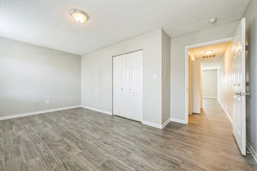 A room with a white door and a grey floor.