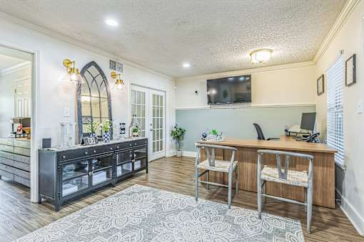 A modern kitchen with a large island and a TV mounted on the wall.