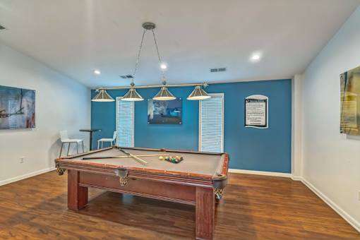 A pool table in a room with blue walls.