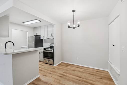 A kitchen with a stove top oven and a refrigerator.