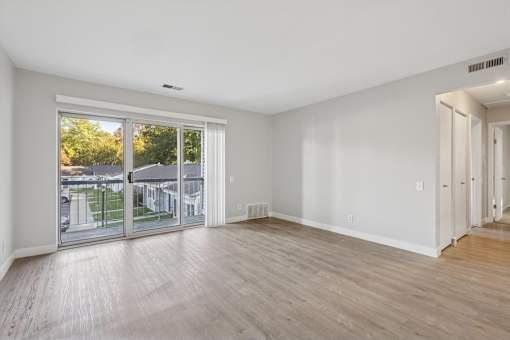 A room with a sliding glass door leading to a balcony.