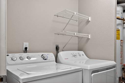 A white washing machine and dryer in a laundry room.
