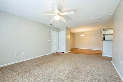 A room with a ceiling fan and carpeted floor.