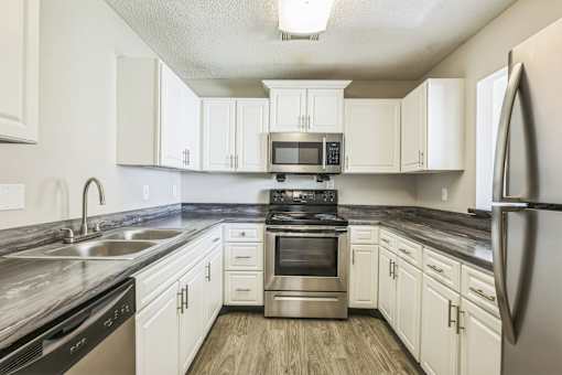 A kitchen with white cabinets and stainless steel appliances.