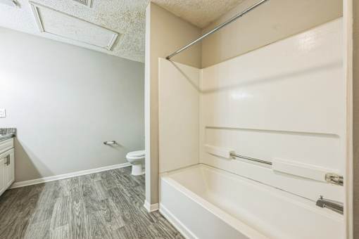 A white bathroom with a toilet and a walk-in shower.
