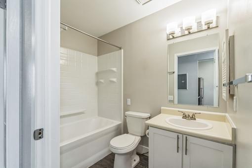 A white bathroom with a toilet, sink, and bathtub.