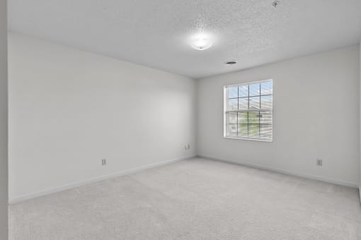 an empty room with white walls and a window