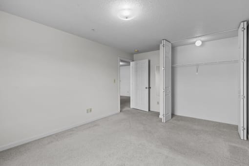 the living room is empty and has a door to the closet