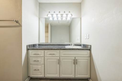 A bathroom with a vanity and a mirror.