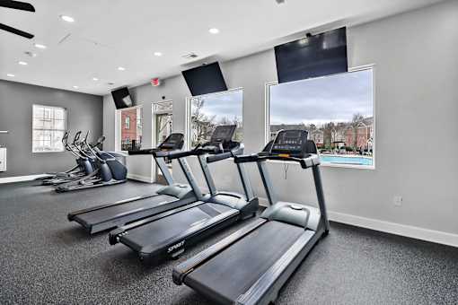 A gym with treadmills and elliptical machines.