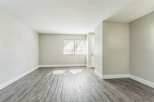 Empty room with wooden flooring and a window.