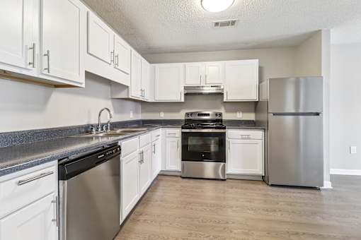 Kitchen with white cabinets and stainless appliances at Avalon Place Columbia SC