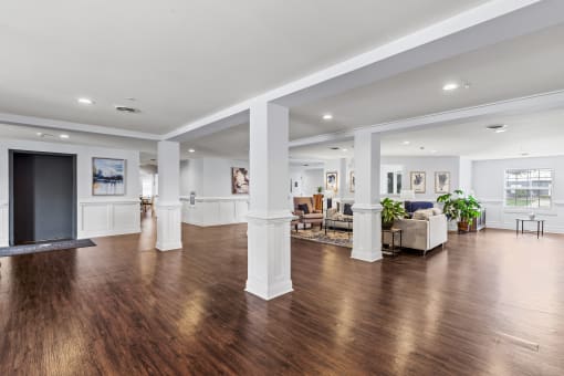 a living room with white pillars and wood floors and a fireplace