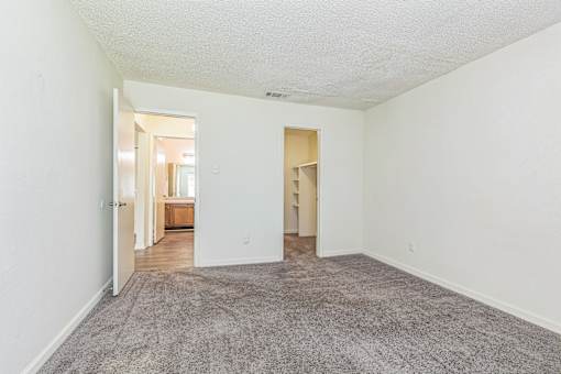 A large, empty room with a carpeted floor and white walls.