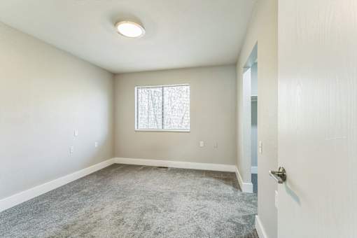 A room with a carpeted floor and a window.