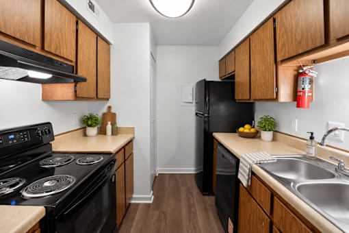 A kitchen with black appliances and wooden cabinets.