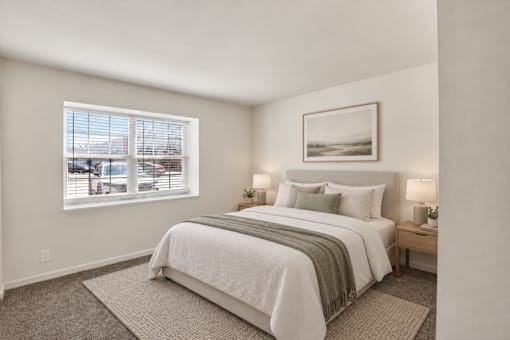 A bedroom with a large bed and a window overlooking a cityscape.