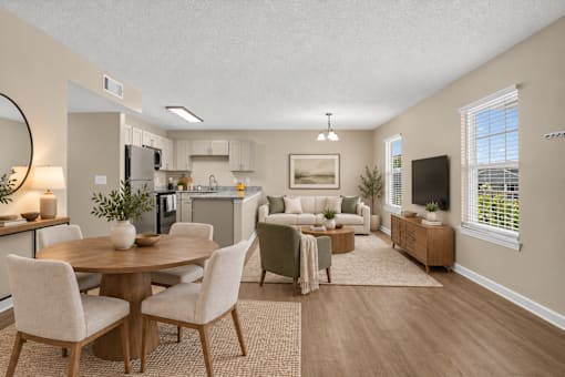 A well-lit, spacious kitchen and living room with a dining table and chairs.