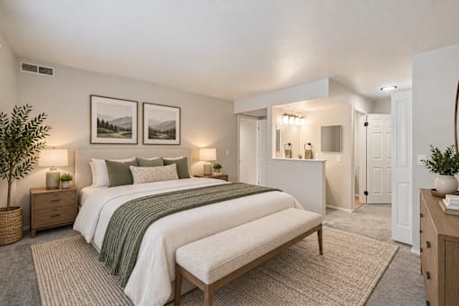 A bedroom with a large bed and two framed pictures on the wall.