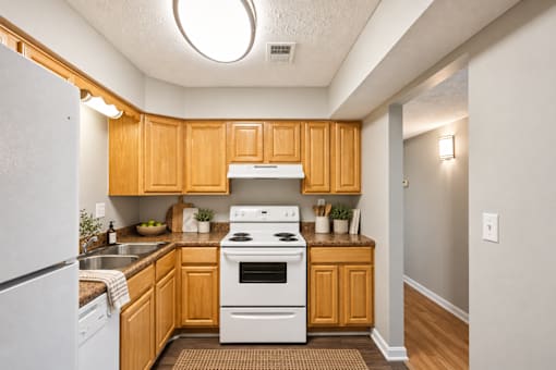 A kitchen with wooden cabinets and a white stove top oven.