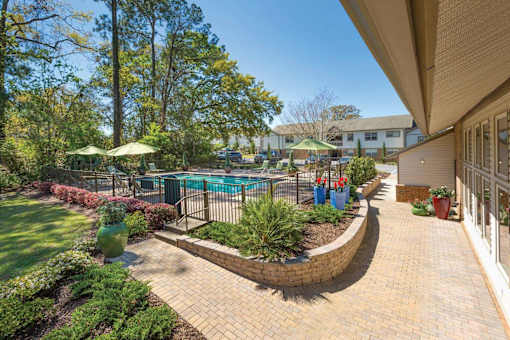 A backyard with a pool and a patio.