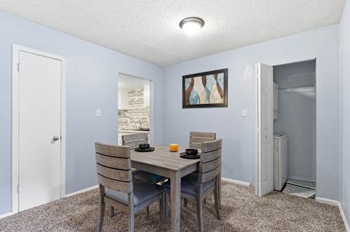A dining room with a table and chairs.