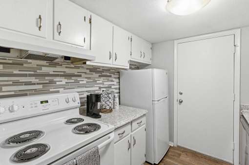 A kitchen with white appliances and cabinets.