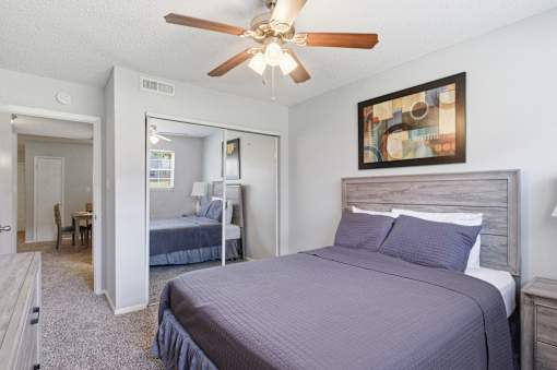 A bedroom with a bed, dresser, and mirror.