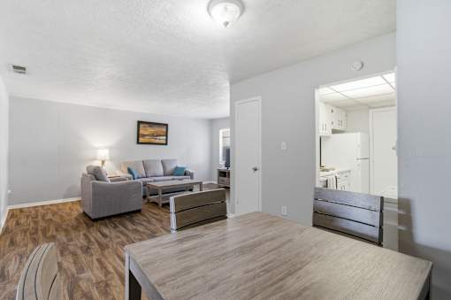 A living room with a grey couch and a wooden table.