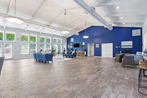 A spacious room with wooden flooring and a large window.