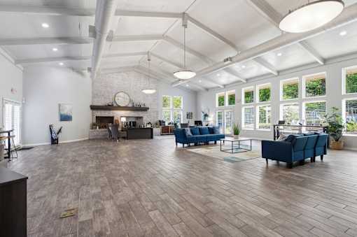A spacious room with wooden floors and a fireplace.