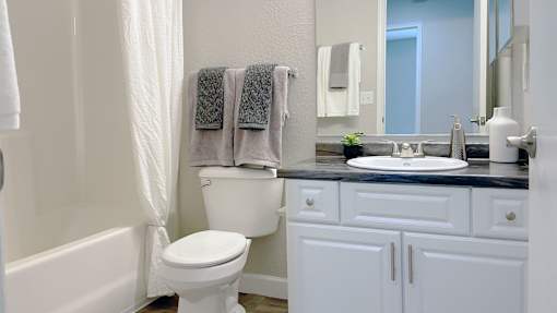 A white toilet sits next to a bathtub in a bathroom.