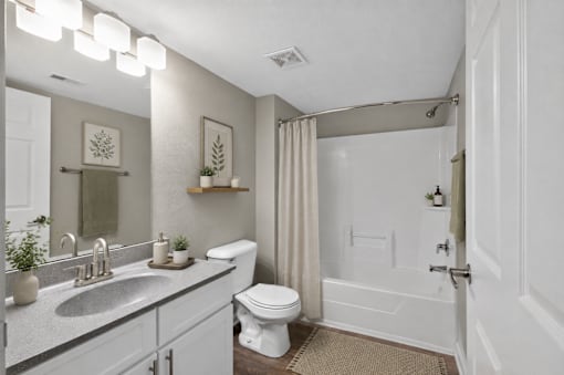 A bathroom with a toilet, sink, and shower.