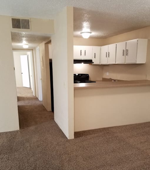 A kitchen area with white cabinets and a black stove top oven.