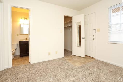 a bedroom with a toilet a sink and a mirror