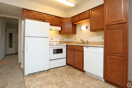 a kitchen with white appliances and wooden cabinets