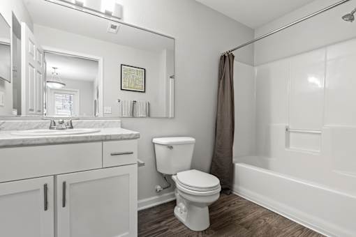 A white bathroom with a toilet, sink, and bathtub.