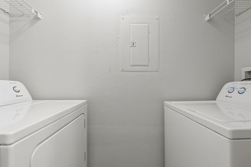 Two front load washing machines in a laundry room.