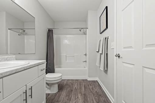 A bathroom with a toilet, sink, and shower.