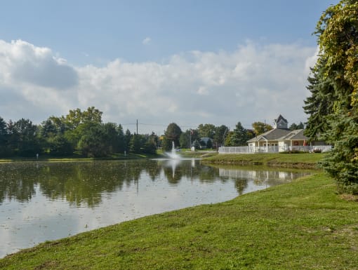 a view of a pond with a house on the other side of it