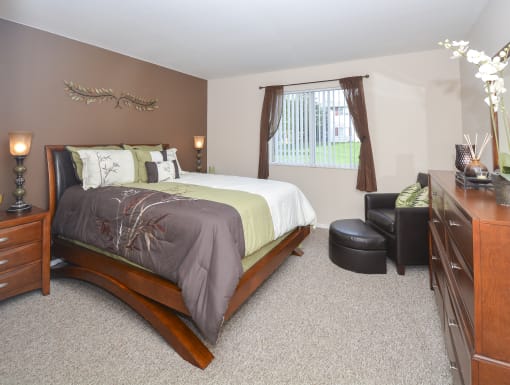 a bedroom with a bed and a dresser and a window