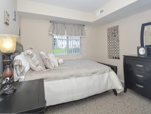 a bedroom with a bed and a dresser and a window