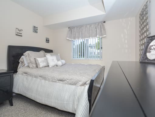 a bedroom with a bed and a desk and a window