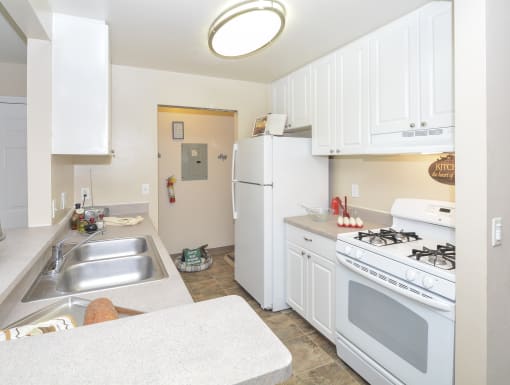 a white kitchen with white appliances and white cabinets