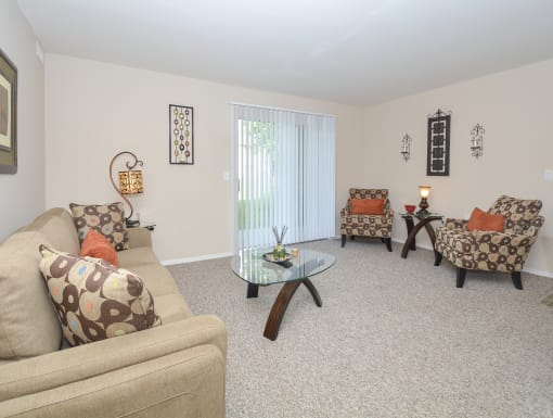 a living room with couches and chairs and a glass coffee table